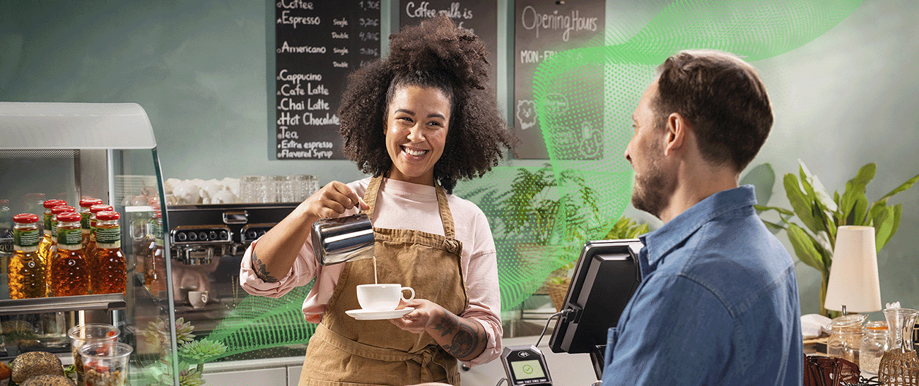Barista serverer kaffe til kunde på kafé